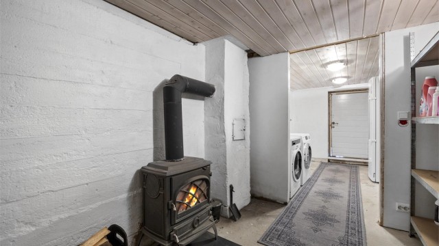 Peisovn i kjeller gir godt med varme opp i huset. Det er også utgang ut fra vaskeromsdelen.