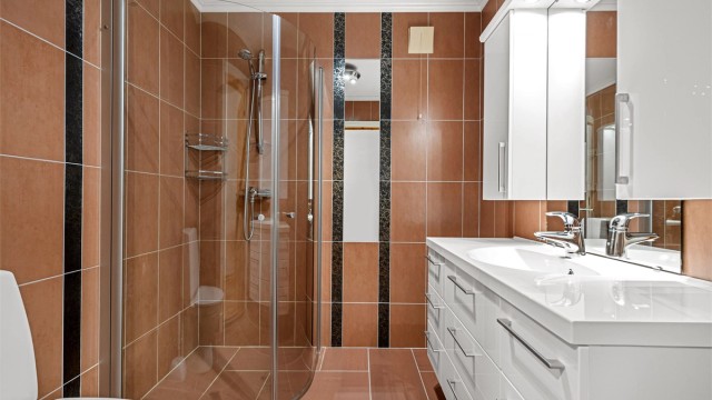 Badet i underetasjen er fra ca. 2004, med gulvvarme og dusjhjørne med glassdører.