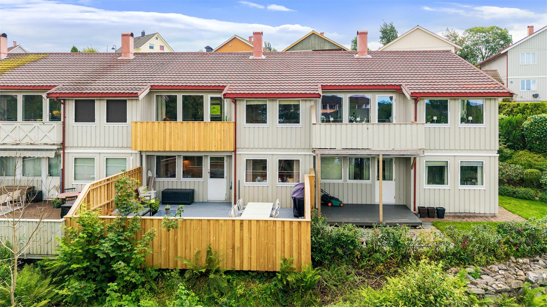 Fasade mot sør med stor terrasse og utgang fra underetasjen.