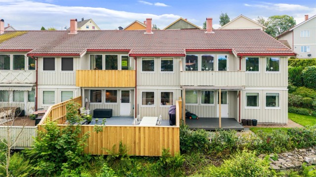 Fasade mot sør med stor terrasse og utgang fra underetasjen.