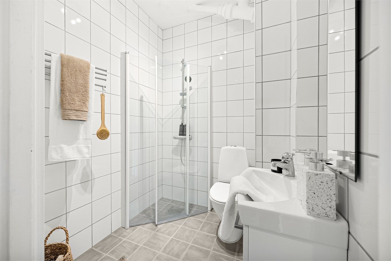 Tidløst bad med flislagt gulv og vegger samt opplegg for vaskemaskin.