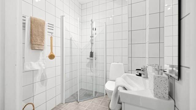 Tidløst bad med flislagt gulv og vegger samt opplegg for vaskemaskin.