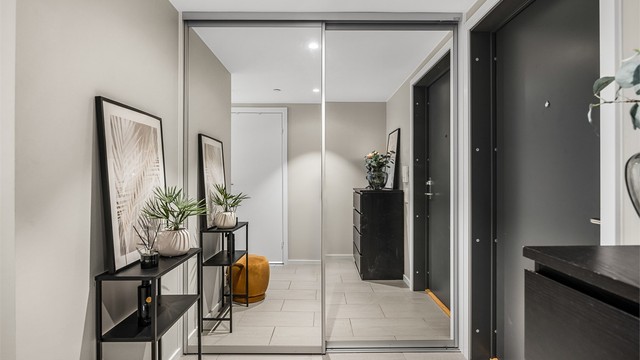 Inngangspartiet er innredet med en romslig skyvedørsgarderobe med speilfronter.