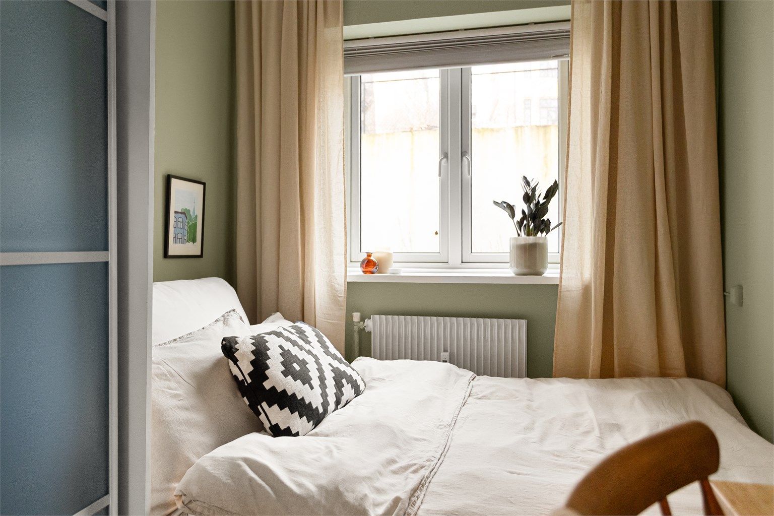 Begge soverommene vender ut mot det frodige gårdsrommet, som gir en rolig og skjermet atmosfære.