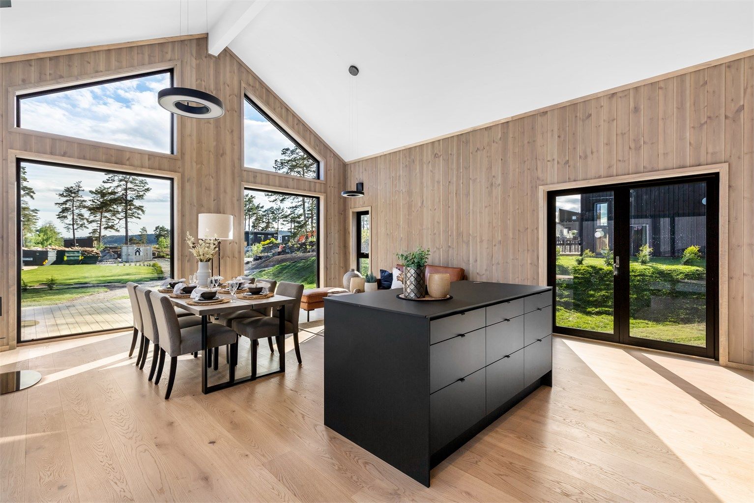 Verandadør på begge langveggene i stua kan åpnes helt så ute og inne flyter i hverandre. 