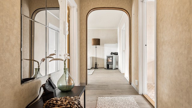 Den buede åpningen fra entréen skaper en elegant overgang til stuen.