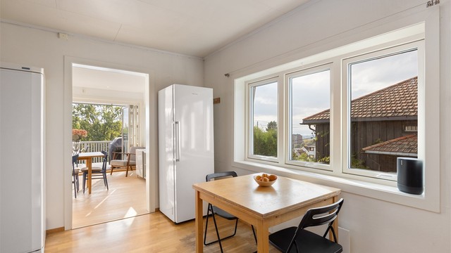 Kjøkkenet har spiseplass og direkte sikt gjennom spisestuen til balkongen.