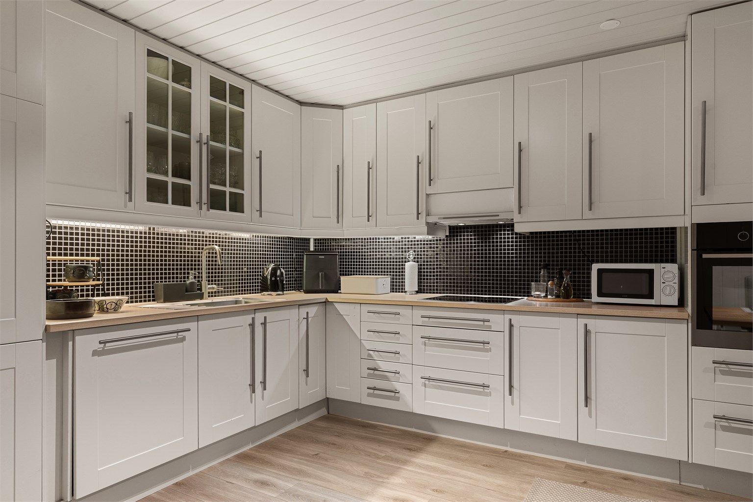 Lyst, pent og velutstyrt kjøkken med integrerte hvitevarer 