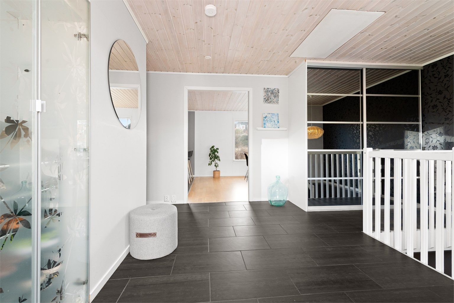 Det er skyvedørsgarderobe med speilfronter i hall/trapperom. Luke i tak med adkomst til kryploft