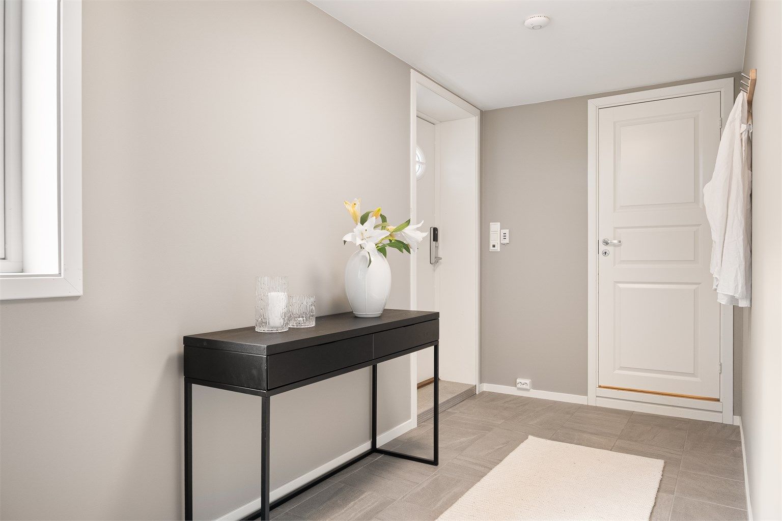 Hybelens inngangsdør har elektronisk kodelås. Innenfor entreen finnes et stort rom byggemeldt som "hobby/redskap".