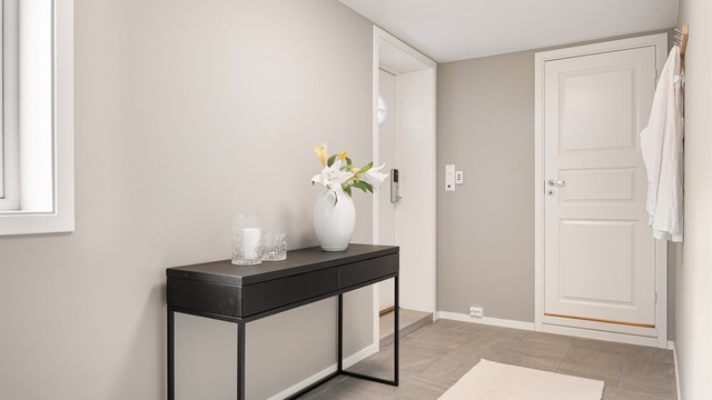 Hybelens inngangsdør har elektronisk kodelås. Innenfor entreen finnes et stort rom byggemeldt som "hobby/redskap".