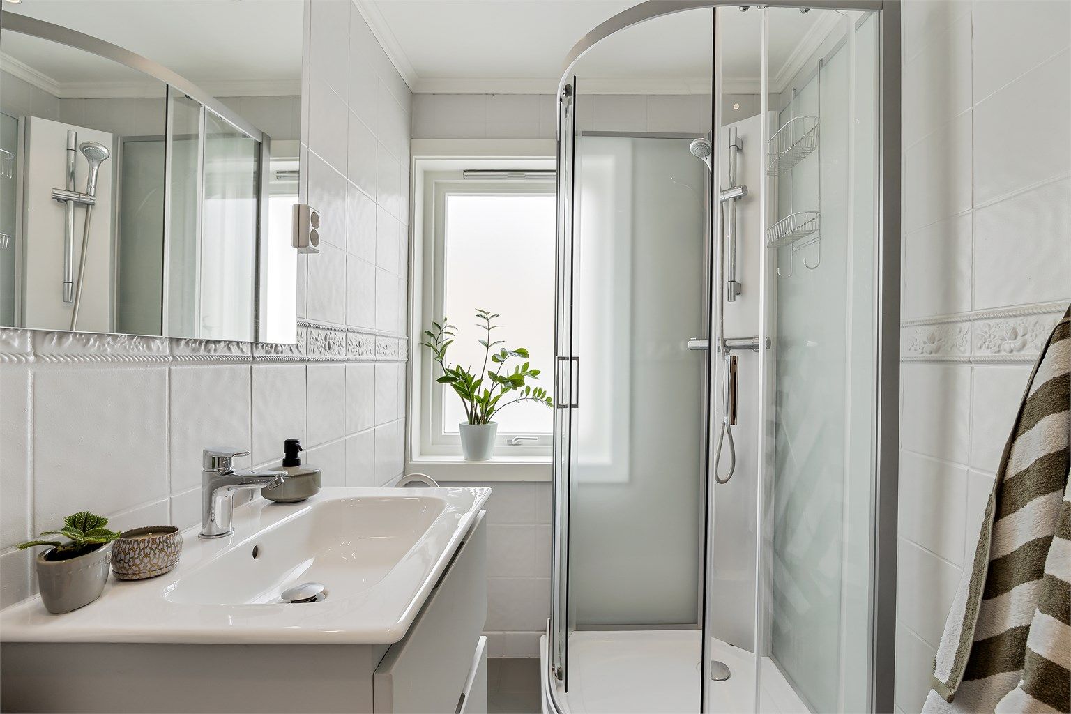Badet er innredet med dusjkabinett, servantinnredning og speil med belysning. Varmekabler i gulv for økt komfort.