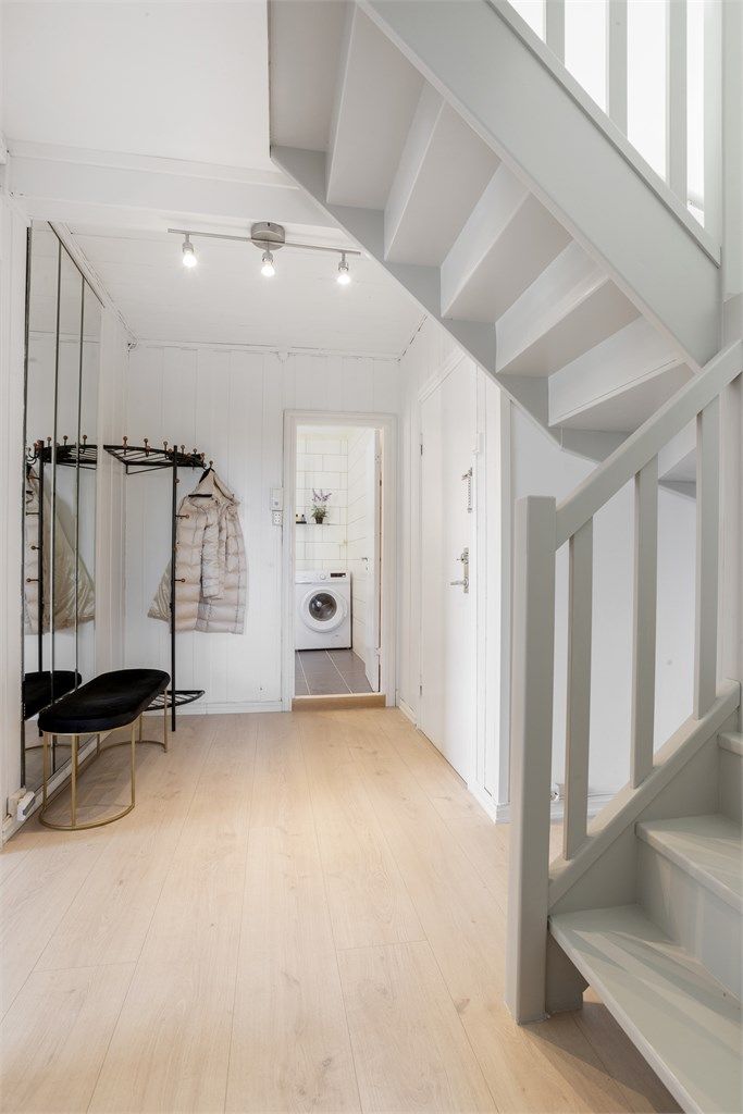 Man kommer inn i en lys og romslig entré med knaggløsning og veggspeil