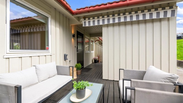 Uteplassen ved inngangen er delvis overbygd og har plass til en sittegruppe.