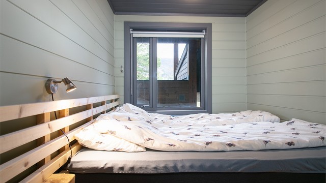 Leilighetens tredje soverom har malt panel og lysmalte overflater.
