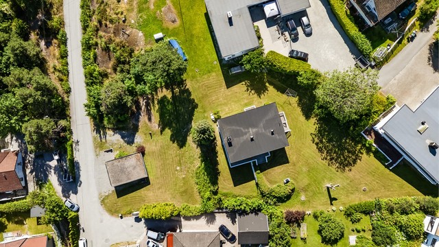 Oversikt over den store tomten med bolig og garasje.