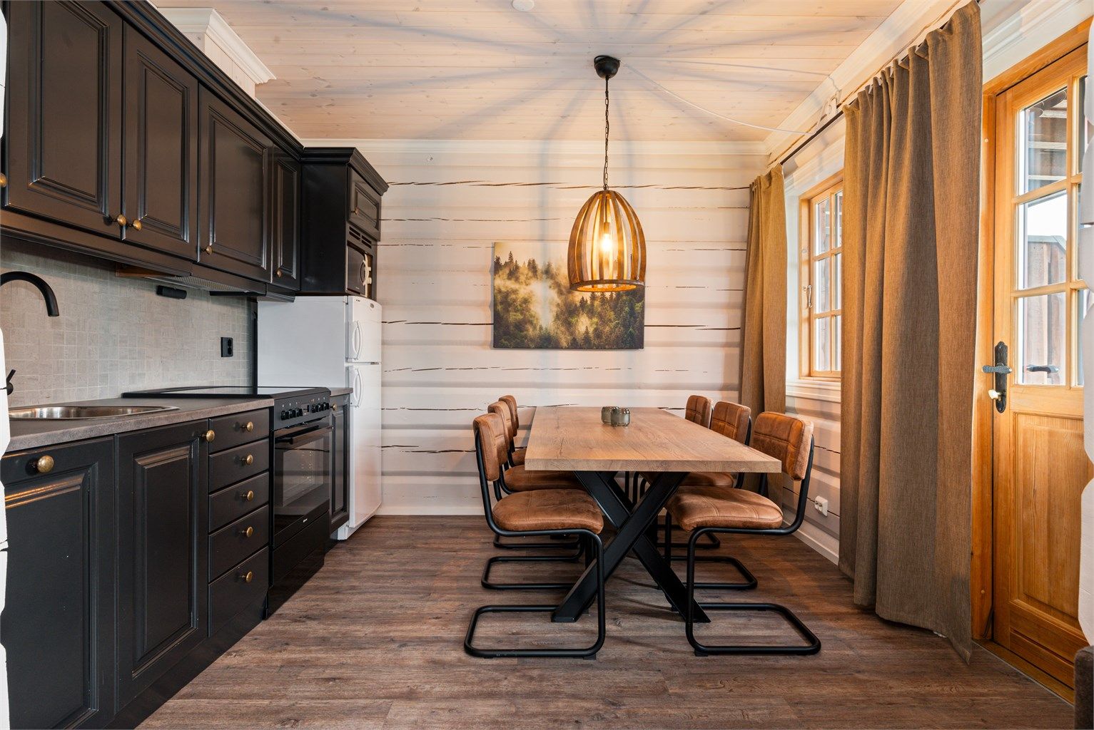 Flott kjøkken med integrerte hvitevarer og medfølgende stor spisegruppe