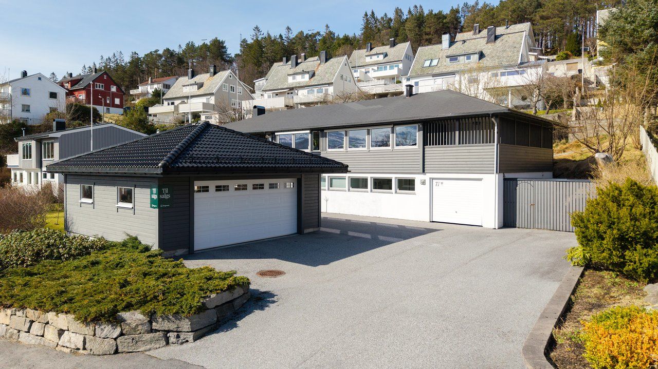 Fasade, garasje og asfaltert parkeringsareal