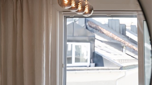 Lyse overflater og gjennomgående laminatgulv skaper et moderne, helhetlig uttrykk og en lun atmosfære.