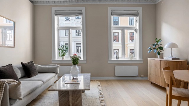 Den romslige stuen er et lyst og luftig oppholdsrom, preget av en imponerende takhøyde på ca. 3,00 meter, elegant stukkatur og rosett i himlingen.