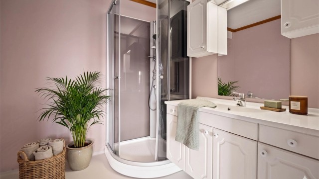 Bad i underetasjen med dusjkabinett, toalett og servant. Rommet har varme i gulvet. Digitalt stylet.