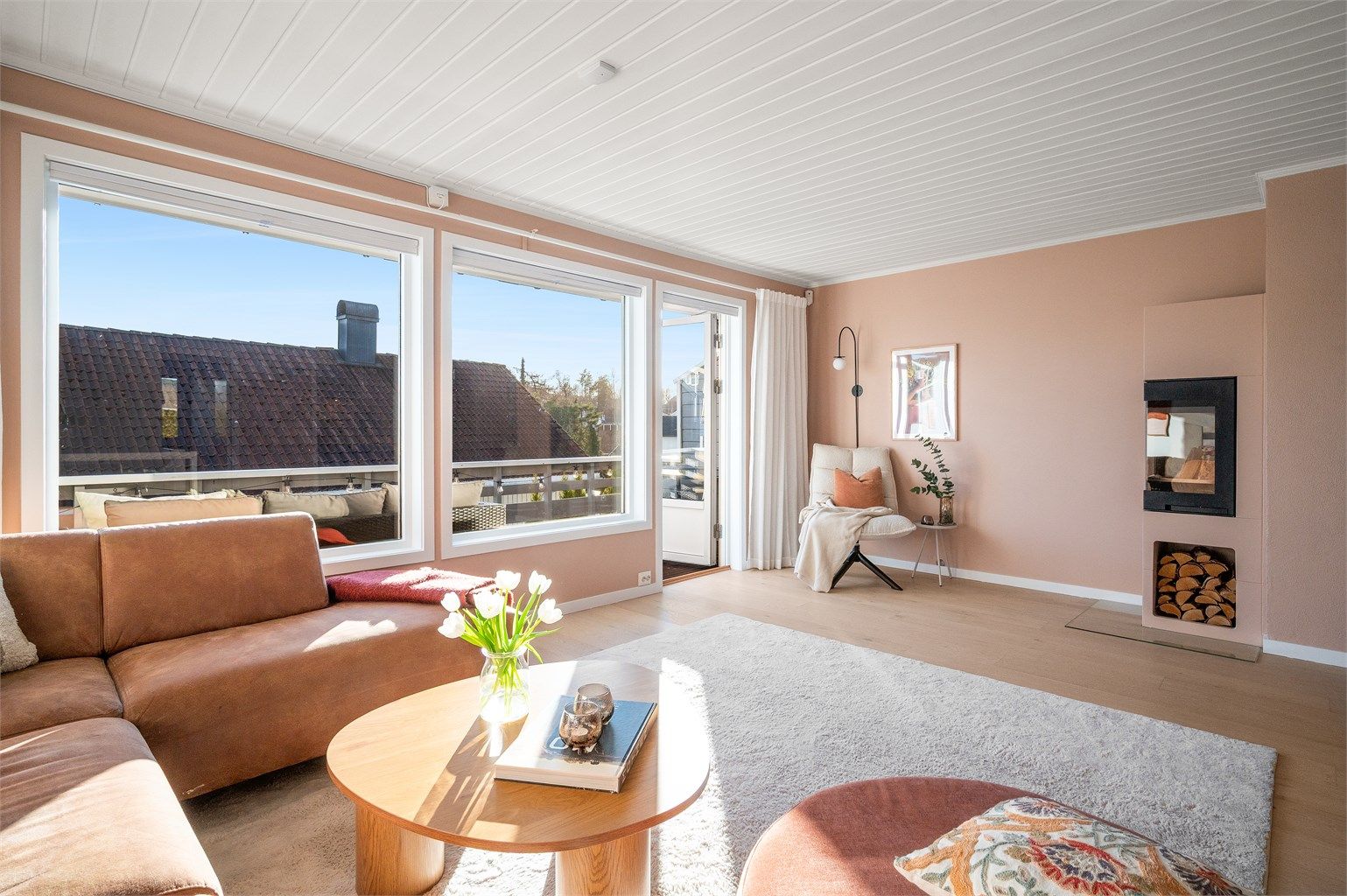 Stuen har god plass til både sofagruppe og TV-løsning, med peis som et naturlig samlingspunkt.