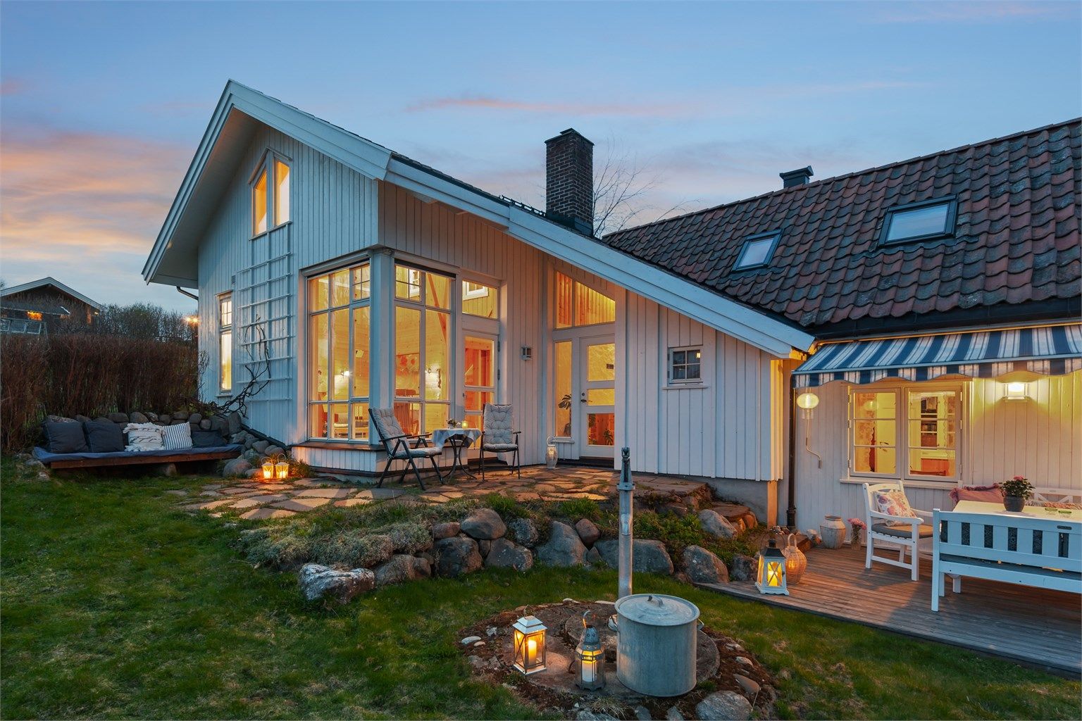 Eiendommen er pent opparbeidet med gårdsplass i grus og belegningsstein, steinheller og natursteinsmurer som gir et solid og helhetlig uttrykk.