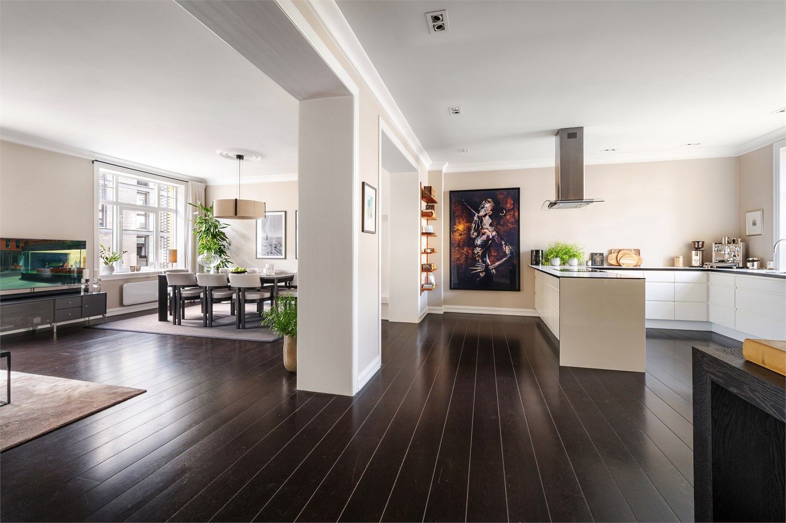 En gjennomgående planløsning binder sammen stue og kjøkken, og skaper en sosial leilighet perfekt for sammenkomster.