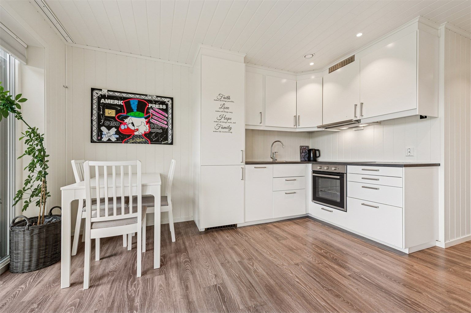 Kjøkkenet er praktisk utformet med god utnyttelse av plassen og har en stilren innredning fra Ikea med integrerte hvitevarer. (Foto: EFKT v/ Lelde Bonfelde-Lapina)