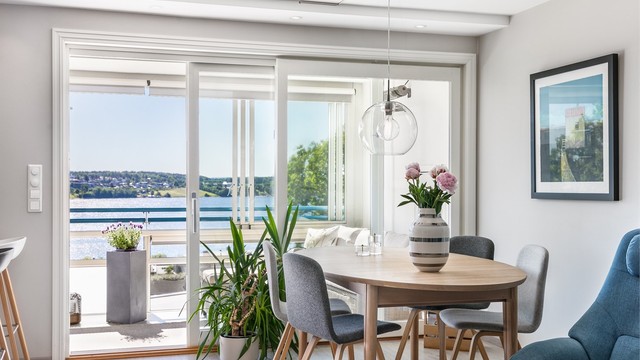 Heve-/skyvedør ble installert i stuen samtidig med oppussing i 2016. Med spisebordet foran de store vinduene får du følge av den fine sjøutsikten til måltidene.