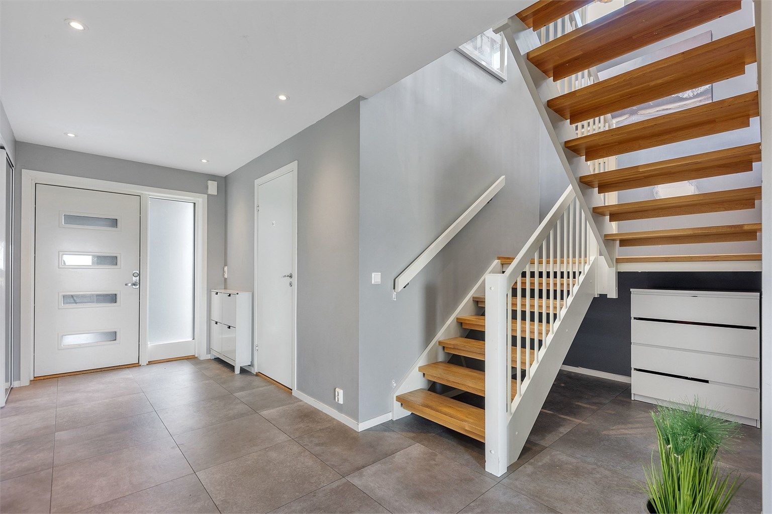 Romslig entré med flislagt gulv og god plass til oppbevaring av yttertøy. Bilder er tatt i 2023 og det vil derfor kunne være slitasje og bruksmerker som ikke fremgår av bildene.