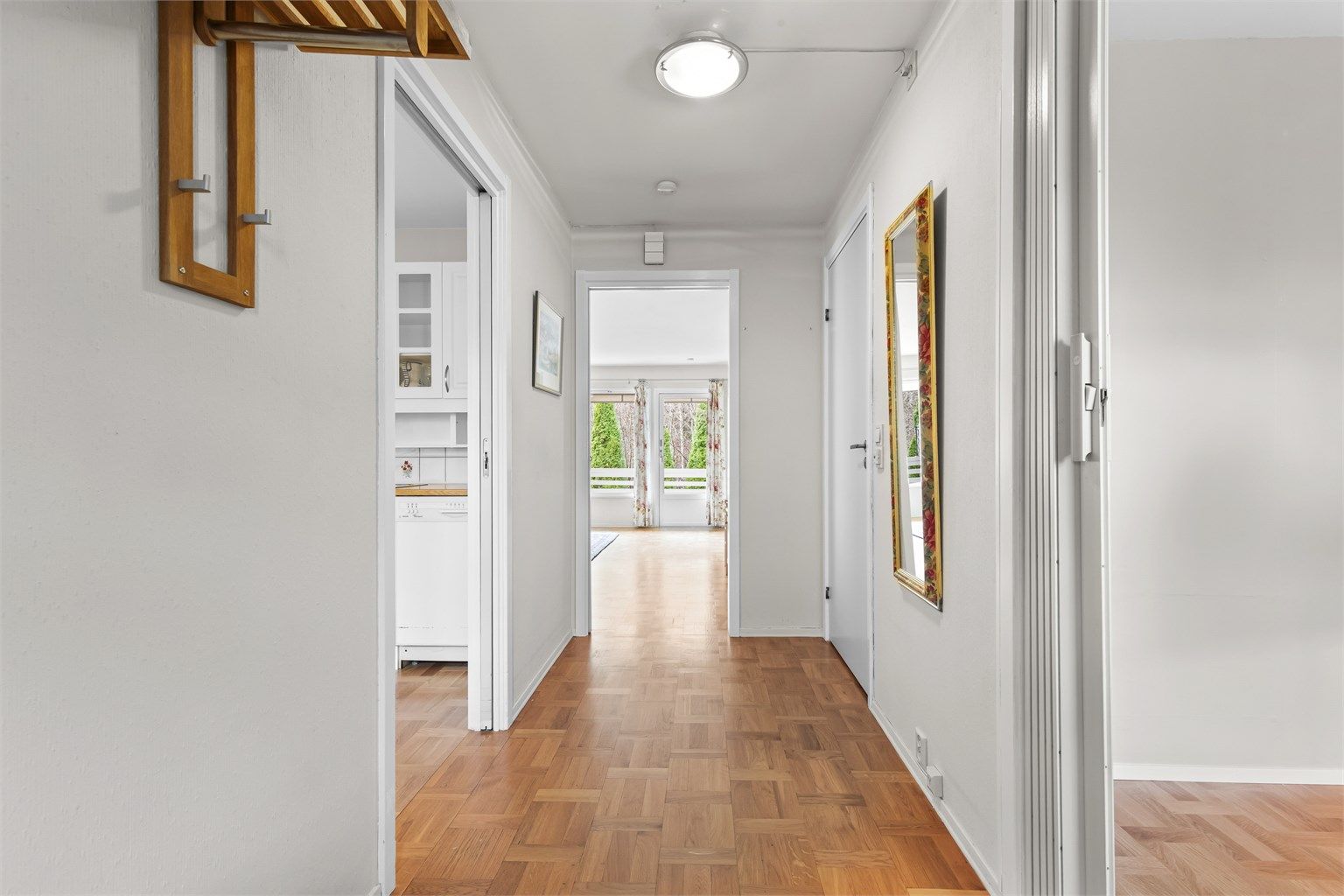 Vel innenfor blir du møtt av en lys entré med parkettgulv som leder videre inn i boligen.