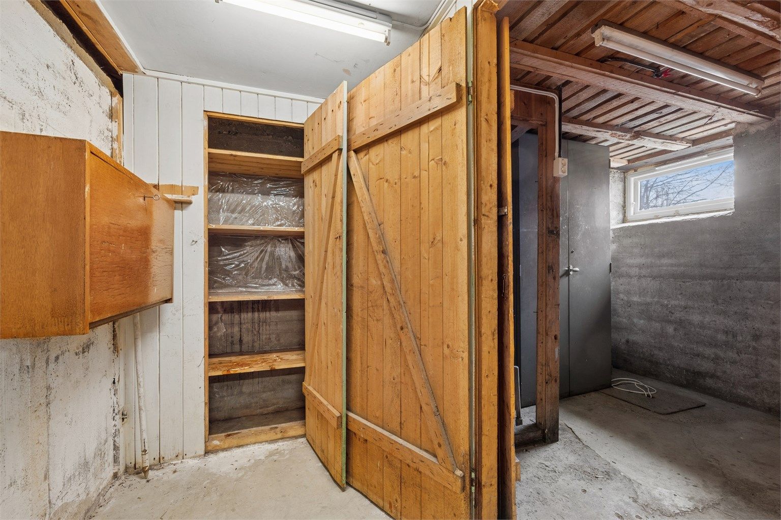 Kjelleren har bod-dører av treverk og utgjør et solid lagringsareal.