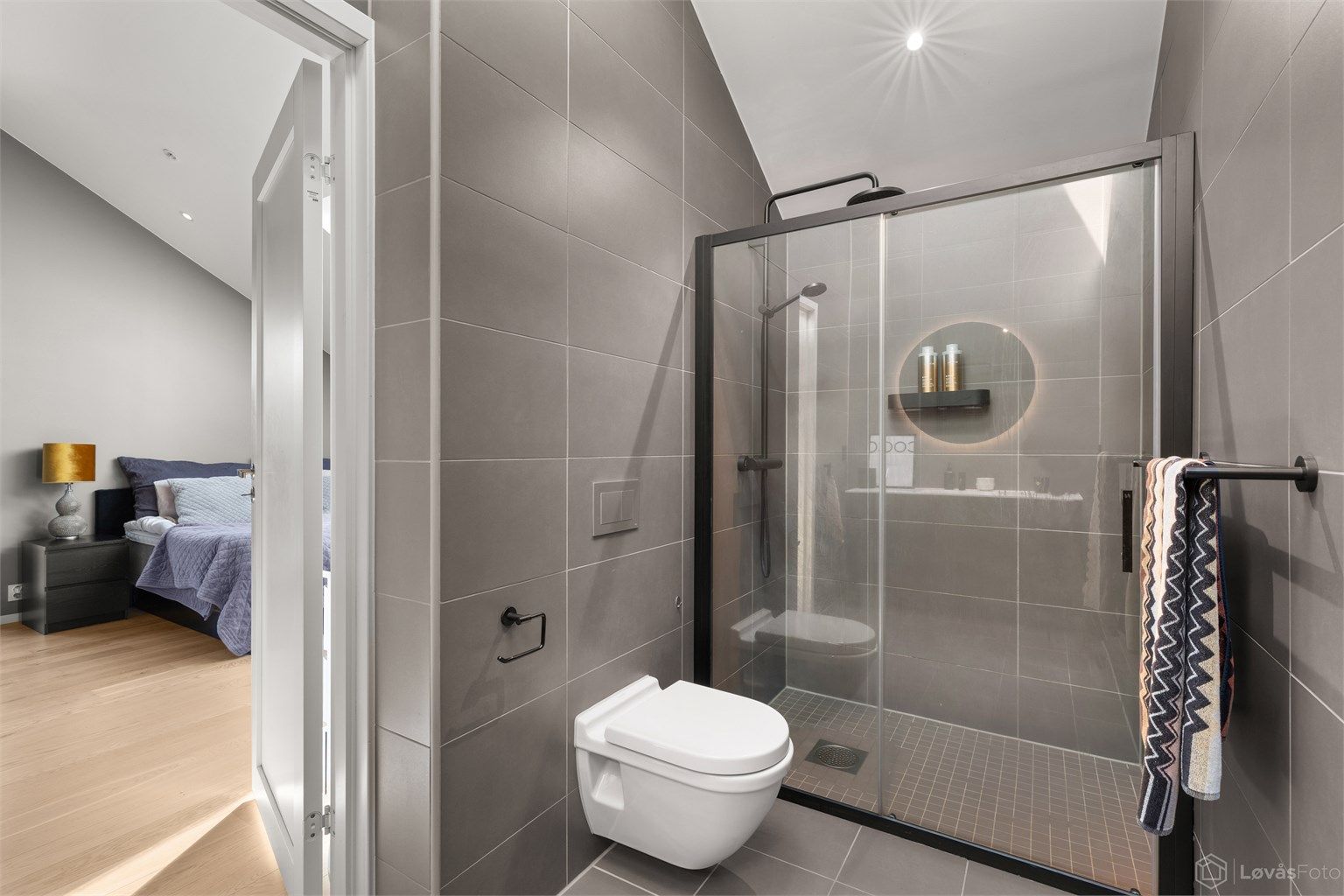 Masterbadet er en naturlig forlengelse av soveromssuiten og er utført med flislagte gulv og vegger, elektrisk gulvvarme og malt himling med integrerte downlights.