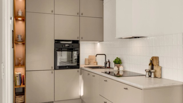 Kjøkkenet er godt utnyttet og har godt med lagringsplass i skap og skuffer og arbeidsflater for matlaging. Skapene er trukket opp mot taket som gir et gjennomført uttrykk.