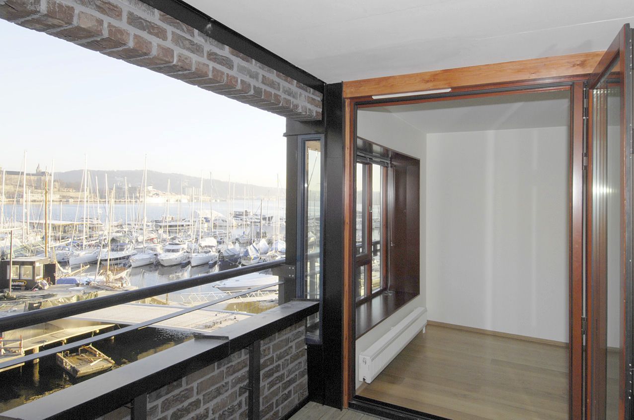 Nyt utsikten fra privat balkong mot marina og fjorden - med idylliske Akershus festning i bakgrunnen.