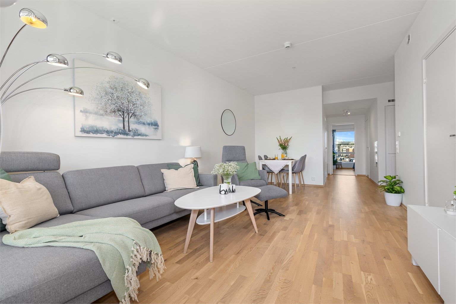 Stuen er lys og romslig, med eikeparkett på gulv og god plass til både sofagruppe og spisebord.