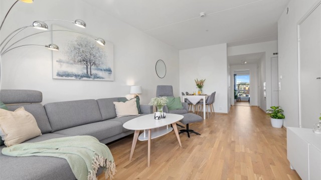 Stuen er lys og romslig, med eikeparkett på gulv og god plass til både sofagruppe og spisebord.