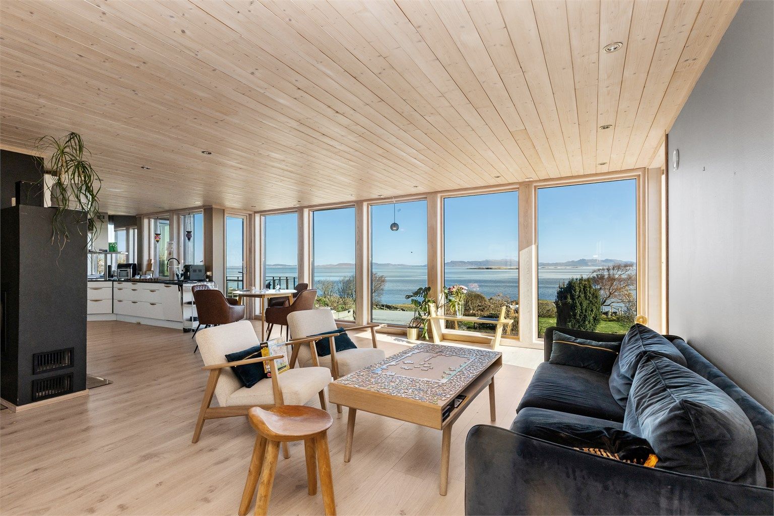 De brede vinduene fra gulv til tak gir en sømløs overgang mellom stuen og det omkringliggende kystlandskapet.
Foto: Marianne Lyse.