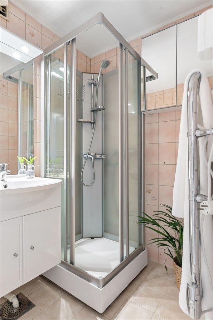 Badet har vegghengt servantinnredning, speil med overlys, dusjkabinett og gulvstående toalett, samt opplegg for vaskemaskin