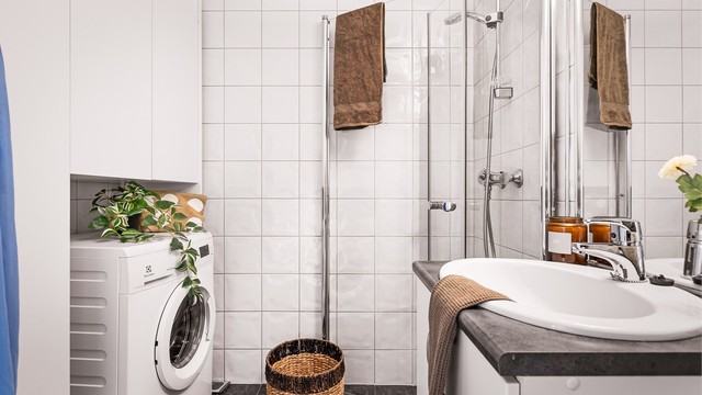 Helfliset baderom med vednbare fusjvegger i glass, opplegg for vaskemaskin, skap og møblement.