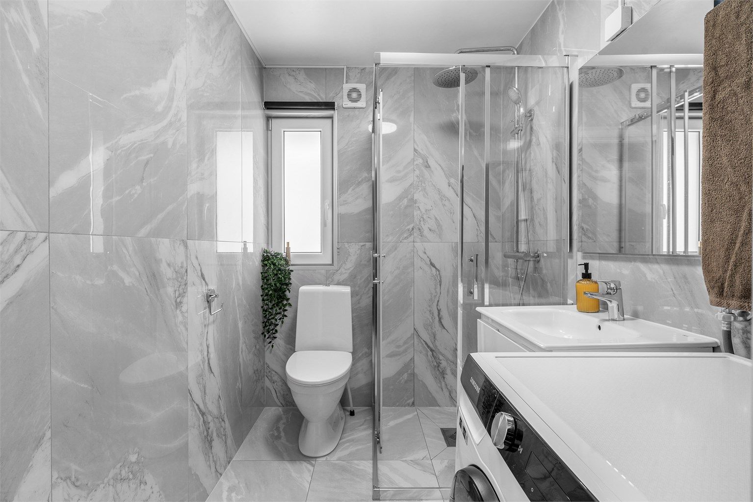 Rommet er innredet med toalett, dusjhjørne med skyvedører i glass og vegghengt servantskap med skuffer og ovenpåliggende servant med ettgreps armatur.