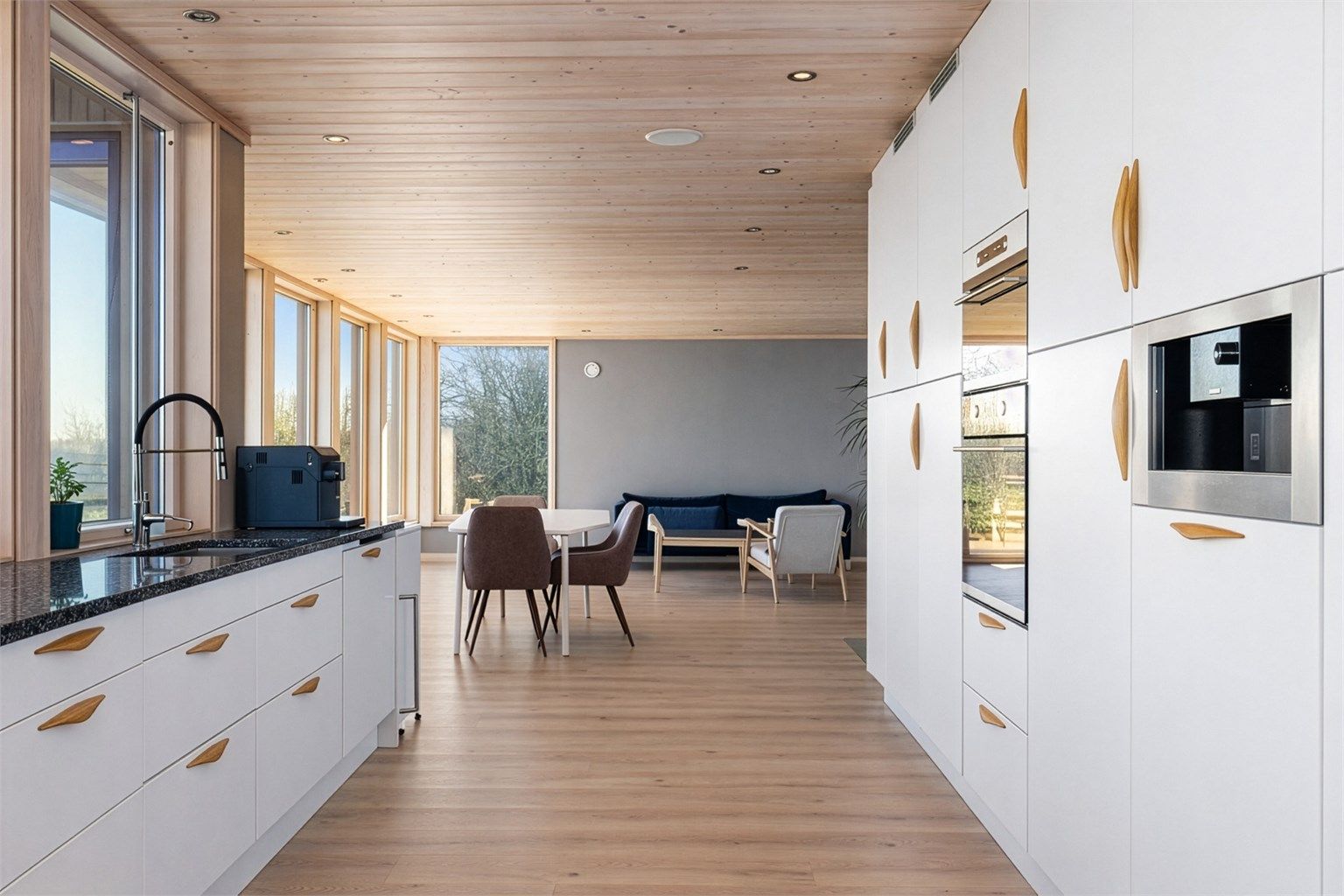 Bildet er redigert ved hjelp av AI.
Kjøkkeninnredningen fra byggeåret har glatte fronter og en solid benkeplate i stein. Kjøkkenet er fullt utstyrt med integrert stekeovn, platetopp, oppvaskmaskin, mikrobølgeovn, kjøleskap, fryser og kaffemaskin.