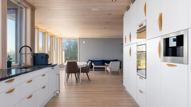 Bildet er redigert ved hjelp av AI.
Kjøkkeninnredningen fra byggeåret har glatte fronter og en solid benkeplate i stein. Kjøkkenet er fullt utstyrt med integrert stekeovn, platetopp, oppvaskmaskin, mikrobølgeovn, kjøleskap, fryser og kaffemaskin.