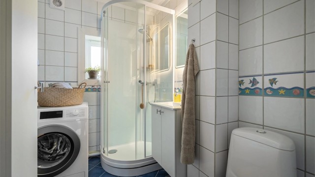 Baderom med flislagte gulv- og veggflater med varmekabler i gulv