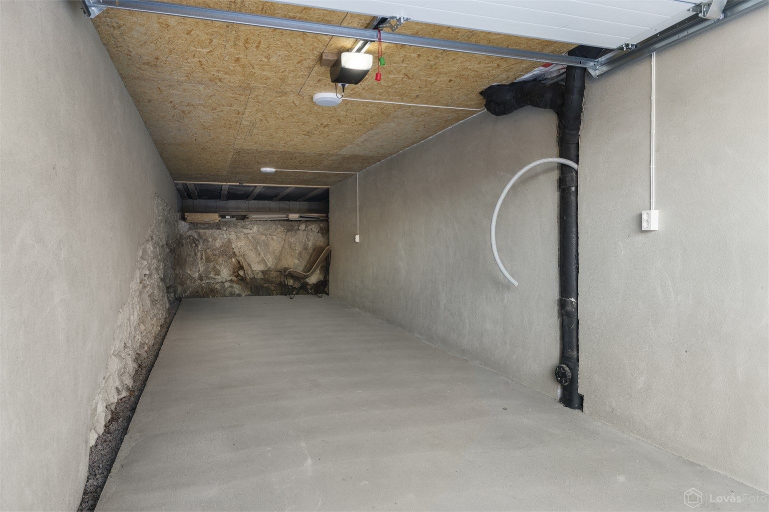 Integrert i boligens underetasje ligger garasjen med plass til 2 biler etter hverandre. Det er lagt trekkerør til garasjen og til legen utvendig parkeringsplass for evt. etablering av elbillader. Ny elektrisk garasjeport i 2025