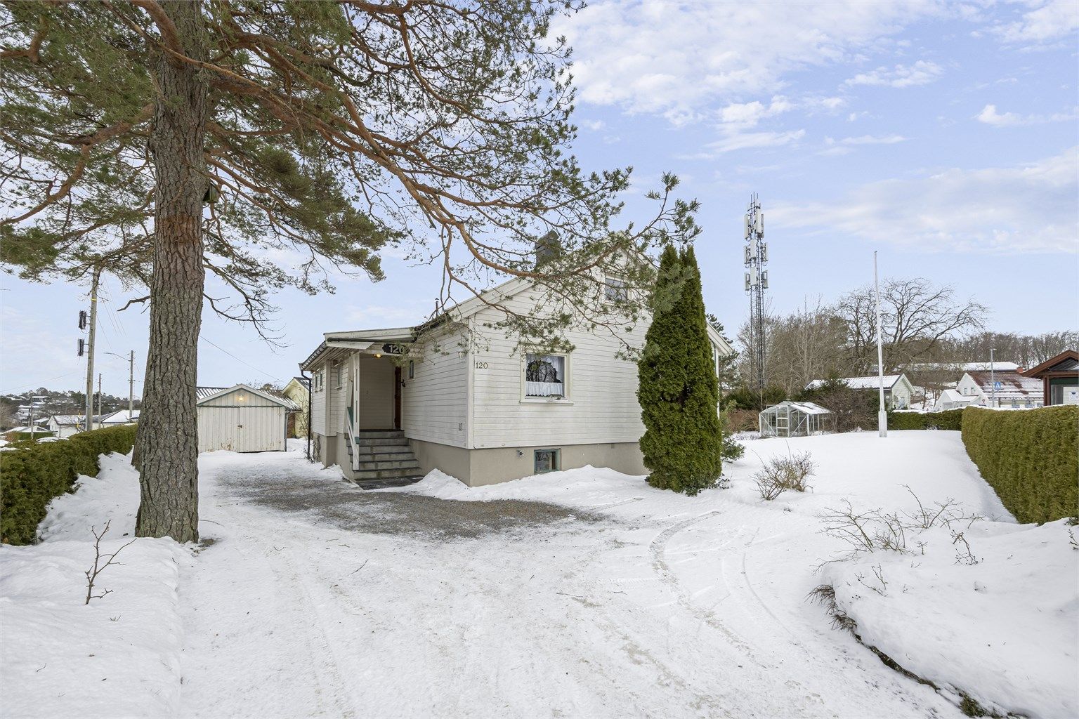 Eiendommen har en frittstående garasje og god plass for flere biloppstillingsplasser på tomten.