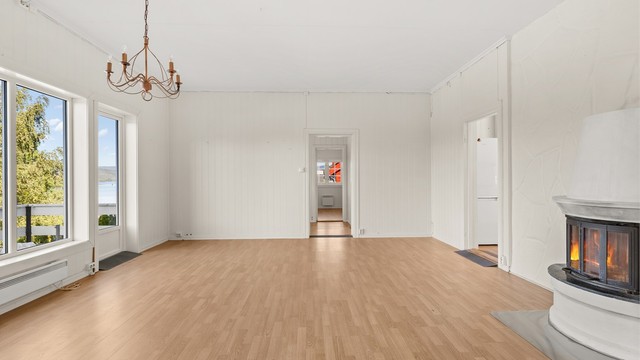 Stuen har god plass til sittegruppe og hyggelig innsyn til peisovnen.