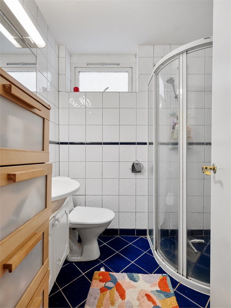 Badet i sokkelleiligheten er helfliset, har gulvvarme og opplegg for vaskemaskin.