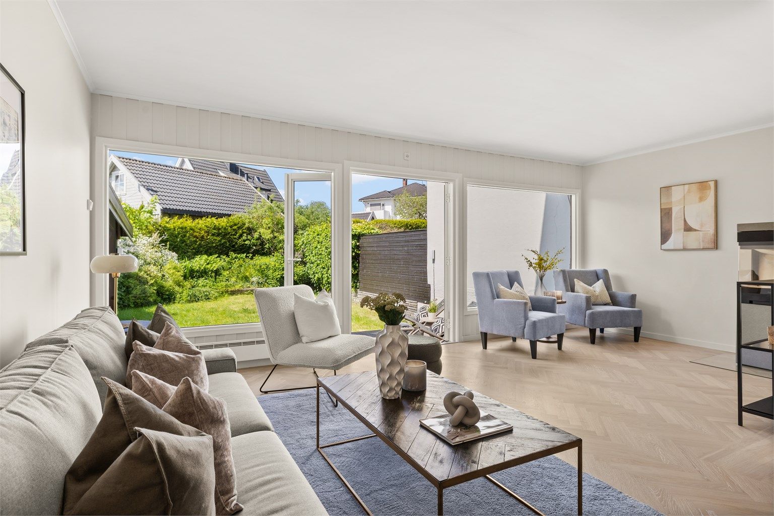 Innbydende stue med vakre heltregulv lagt i klassisk fiskebensmønster, nyslipt og vokset i 2025, som sammen med vegger malt i moderne og harmoniske farger gir rommet et elegant og tidløst uttrykk.